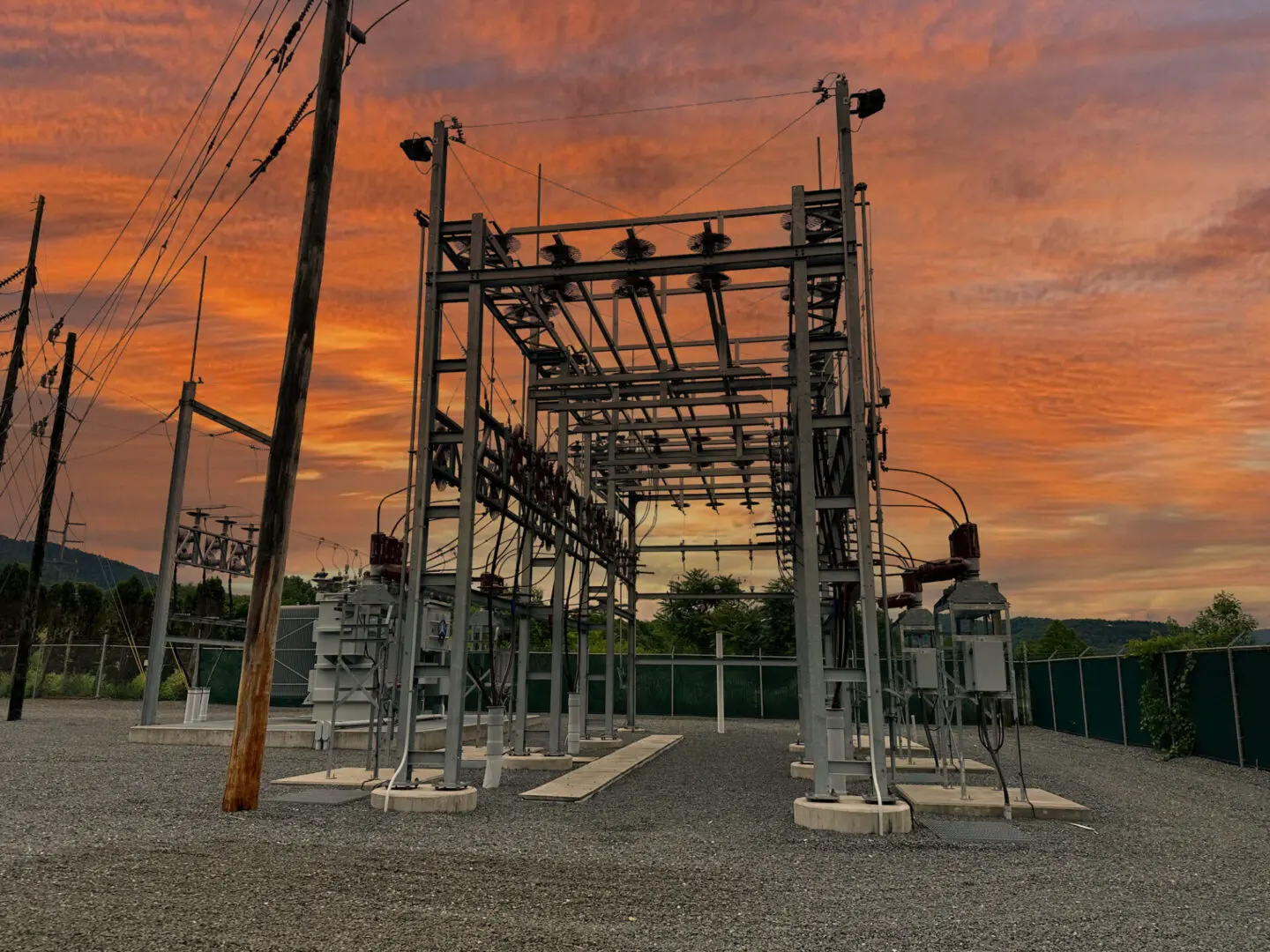 Electrical substation against a vibrant sunset sky.