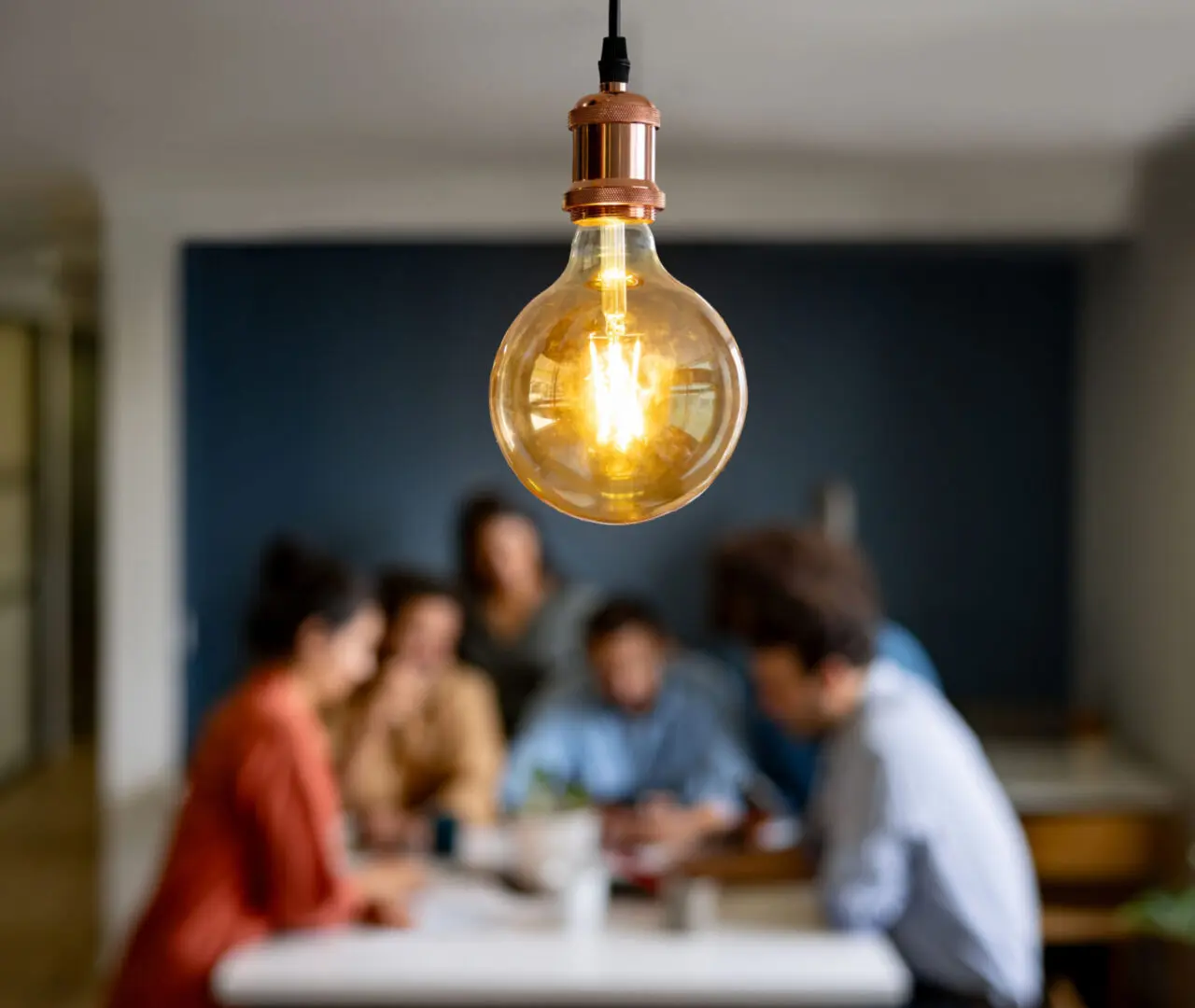 Light bulb above people in discussion.