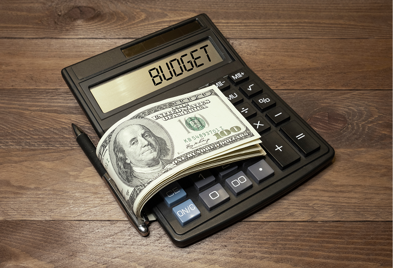 Calculator with cash and pen on table.