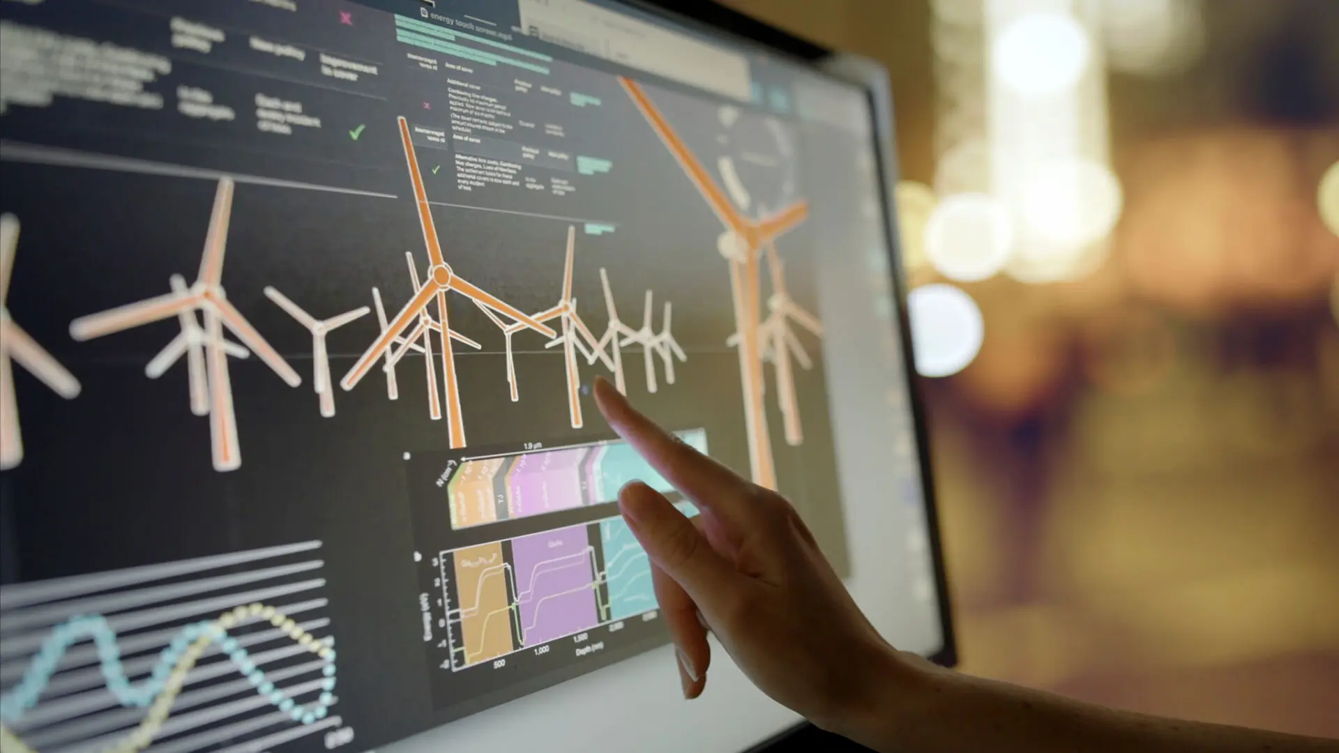Finger pointing at wind turbine data display.